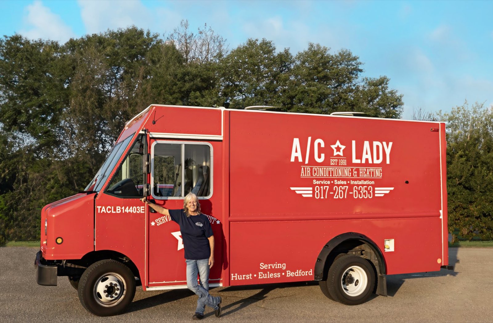 The AC Lady standing beside her red A/C Lady service truck